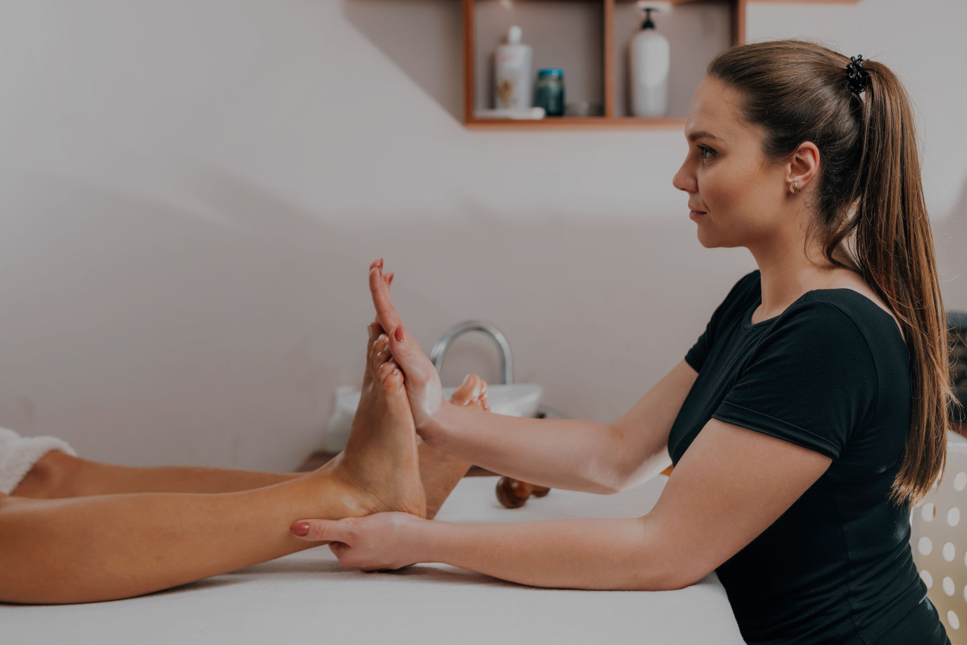photo d'illustration de la prestation réflexologie - FPS. Femme massant le pied de son patient.